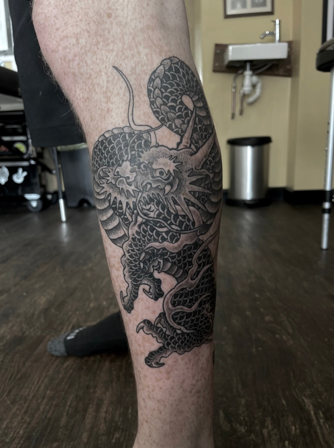 Black and grey Japanese dragon tattoo on the lower leg