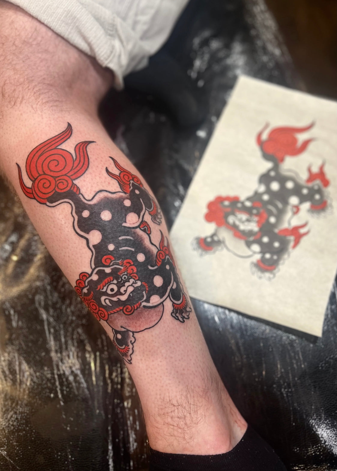 Traditional shishi tattoo beside its original painted reference